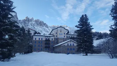 a large building in the snow with snow covered trees at Residence Grand Hotel Carezza in Nova Levante