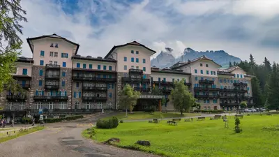 a large building with a park in front of it at Residence Grand Hotel Carezza in Nova Levante