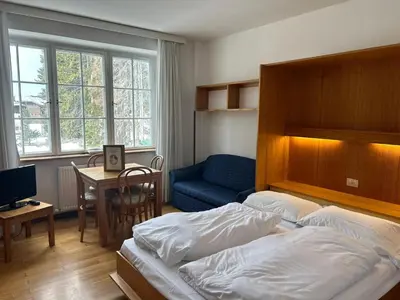 a bedroom with a bed and a chair and a desk at Residence Grand Hotel Carezza in Nova Levante