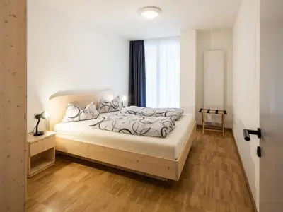 a bedroom with a large bed and a window at Vintlerhof in Bressanone