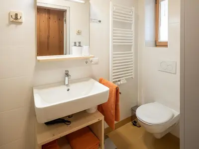 a white bathroom with a sink and a toilet at Vintlerhof in Bressanone