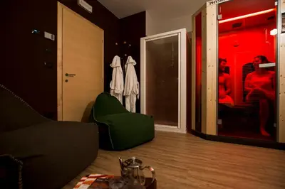 a living room with a couch and a green chair at Hotel Erica in Tesero