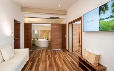 a living room with a white couch and a flat screen tv at Hotel Mandelhof in Appiano sulla Strada del Vino