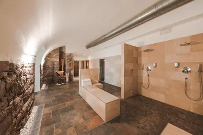 a large bathroom with a shower and a sink at Hotel Mandelhof in Appiano sulla Strada del Vino