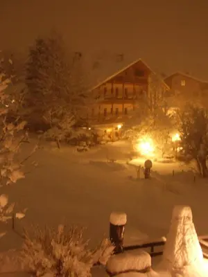 a snow covered campus at night with a building at Albergo Bellaria in Carano