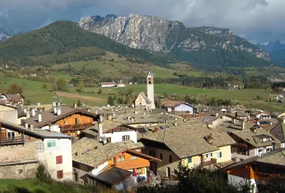 a small town with houses and mountains in the background at Albergo Bellaria in Carano