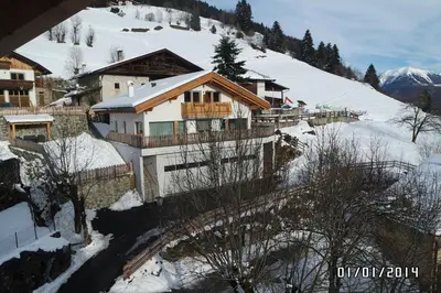 a house on a snowy hill with a mountain at Saxlhof in Stanghe