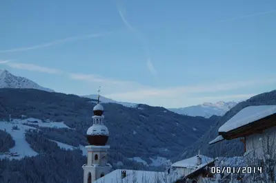 a white tower with a cross on top of a mountain at Saxlhof in Stanghe