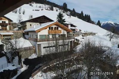 a house on a snowy hill with a mountain at Saxlhof in Stanghe