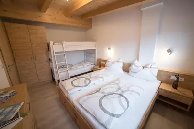 a bedroom with a large white bed with a ladder at Saxlhof in Stanghe