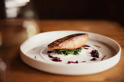a white plate with a piece of food on a table at Diana Dolomites in La Villa