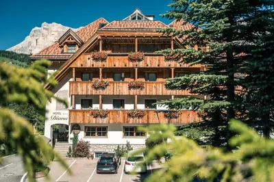 a large building with cars parked in front of it at Diana Dolomites in La Villa