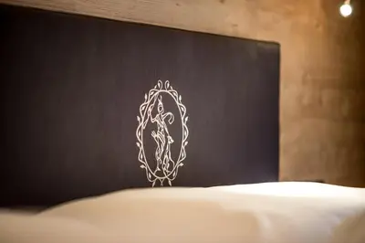 a headboard of a bed with a white design on it at Diana Dolomites in La Villa