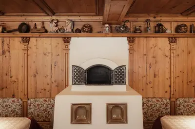 a fireplace in a room with wooden walls at Diana Dolomites in La Villa