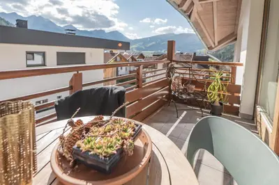 a balcony with a table with a plant on it at Supperior Appartement in Rasùn di Sotto