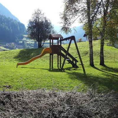 a playground with a slide in a field at Casa con vista a Moena in Moena