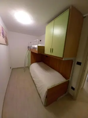a small room with a bed and a cabinet at Casa con vista a Moena in Moena