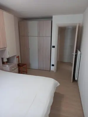an empty room with a bed and a kitchen at Casa con vista a Moena in Moena