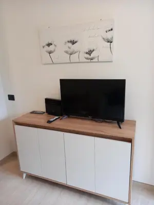 a flat screen tv sitting on top of a white cabinet at Casa con vista a Moena in Moena
