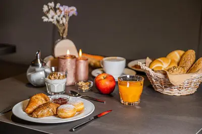 a table with a plate of pastries and a basket of bread at Garni La Ciasota 3s in La Villa