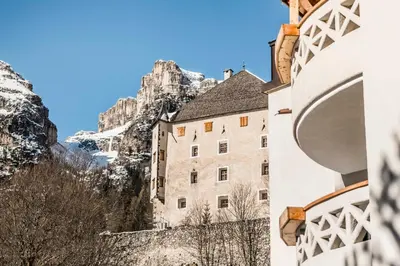 a building with a mountain in the background at Garni La Ciasota 3s in La Villa