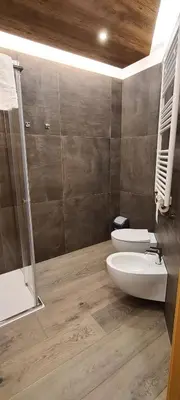 a bathroom with two toilets and a shower at Appartamenti Home Service in Arabba