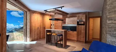 a kitchen with a counter with stools in it at Appartamenti Home Service in Arabba