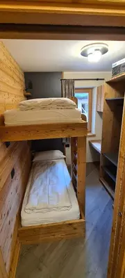 a room with two bunk beds in a cabin at Appartamenti Home Service in Arabba