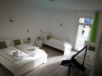 a living room with two white beds and a window at Iceman Room's Central in Bolzano