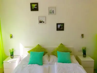 a bedroom with two beds with green and white pillows at Iceman Room's Central in Bolzano