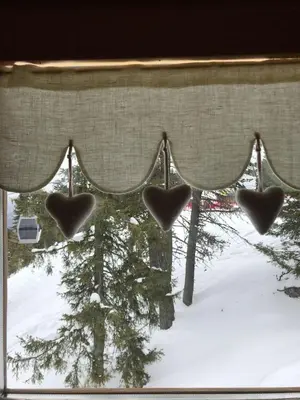 a window with hearts hanging from a curtain at Chalet Biancaneve - Alpe Cermis Cavalese in Cavalese