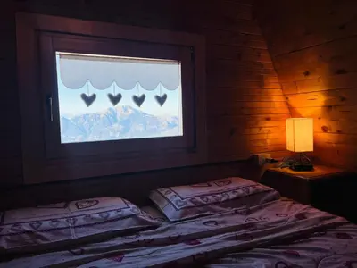 a bedroom with two beds and a window with a view at Chalet Biancaneve - Alpe Cermis Cavalese in Cavalese