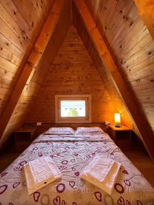 a bedroom with a bed in a wooden attic at Chalet Biancaneve - Alpe Cermis Cavalese in Cavalese