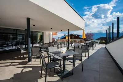 a restaurant with a table and chairs on a patio at Pension Schlaneiderhof in Meltina