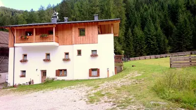 a building with a balcony on the side of a field at Agriturismo Feur Hof in San Martino in Badia
