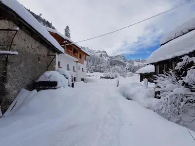 a snow covered road in front of a house at Agriturismo Feur Hof in San Martino in Badia