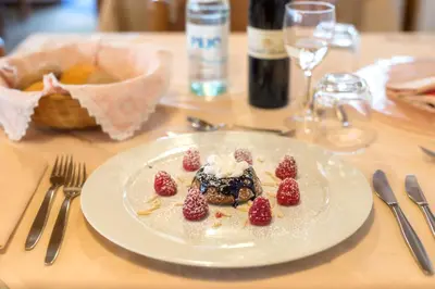 a plate of food with strawberries on a table at Hotel Canada in Predazzo
