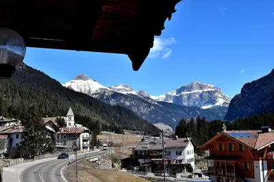 a view of a town with snow capped mountains at Hotel Vajolet in Mazzin
