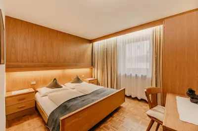 a bedroom with a large bed and a window at Apartments Thaler Irina in Ortisei