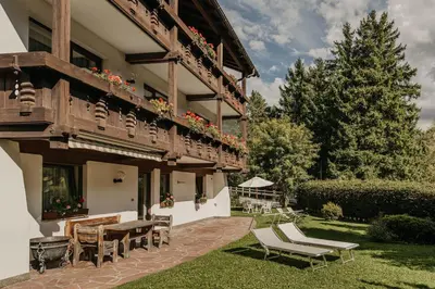 a building with a patio with a table and chairs at Apartments Thaler Irina in Ortisei