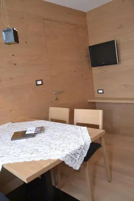 a dining room table with two chairs and a television at Apartments Thaler Irina in Ortisei