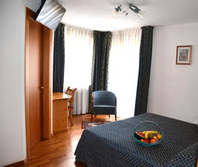 a bedroom with a bed with a bowl of fruit on it at Hotel Corona in Carano