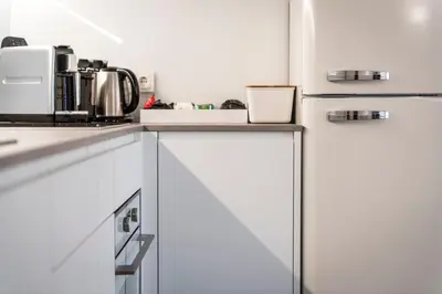 a kitchen with white cabinets and a coffee maker at Apartment Valentina in Bressanone