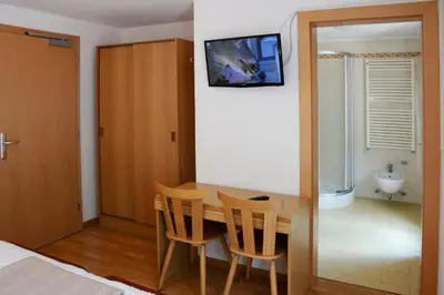 a room with a table and chairs and a television at Casa Teresa Martin in San Vigilio Di Marebbe