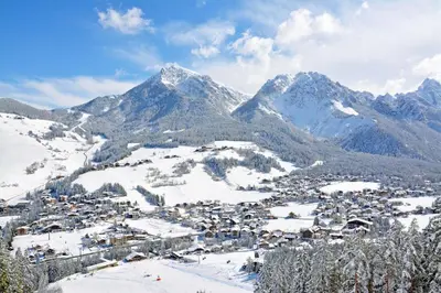 a town covered in snow with mountains in the background at Casa Teresa Martin in San Vigilio Di Marebbe