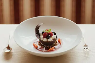 a dessert on a white plate with a spoon at Hotel Colbricon Beauty & Relax in San Martino di Castrozza