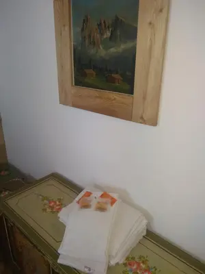 a pile of towels on a table under a painting at Steila da Mont Campitello in Campitello di Fassa