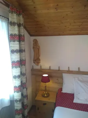 a bedroom with a bed and a table with a lamp at Steila da Mont Campitello in Campitello di Fassa