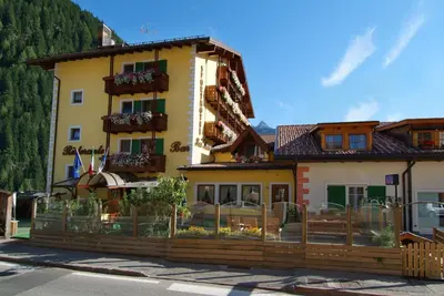 a building with a fence in front of it at Sport Hotel Sass Maor in Predazzo