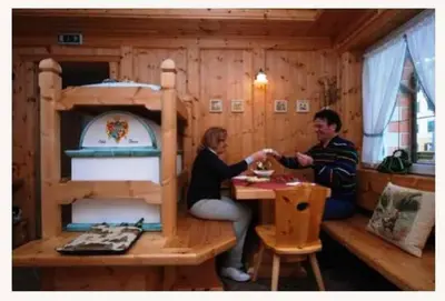 a man and a woman sitting at a table in a play house at Sport Hotel Sass Maor in Predazzo